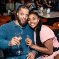 Couple smiling with champagne glasses at restaurant