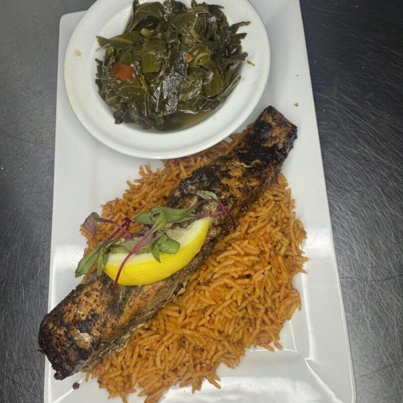 Grilled fish on jollof rice with collard greens